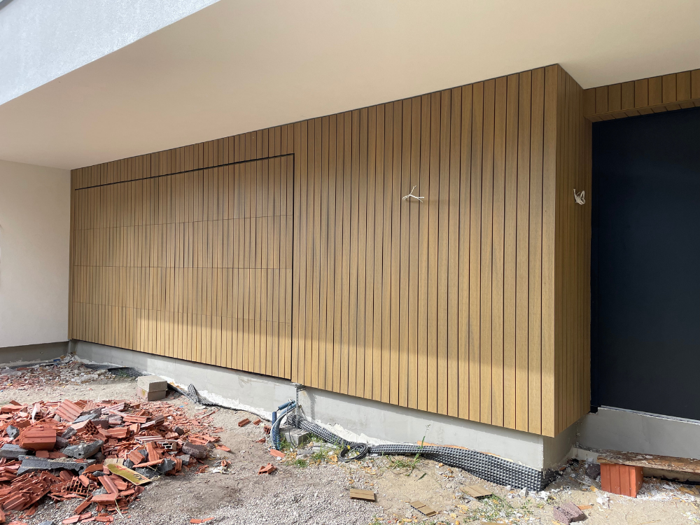 Deska kompozytowa elewacyjna UltraShield® Naturale UH62 w kolorze Oak zamontowana na elektrycznej bramie garażowej