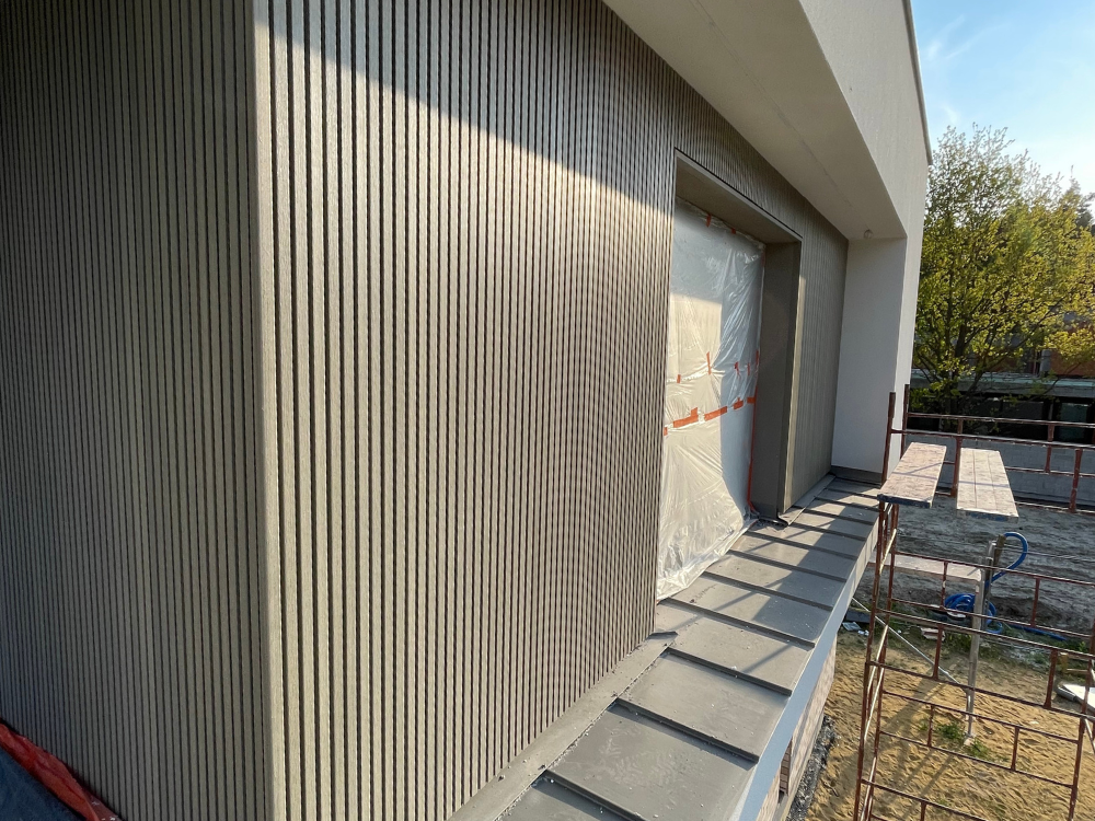 Kompozytowe deski elewacyjne UltraShield® Naturale UH46 w kolorze Antique zamontowane na górnym piętrze budynku jednorodzinnego