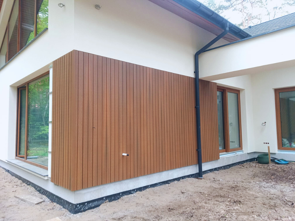 ściana domu parterowego pokryta deskami UH62 w brązowym kolorze Teak