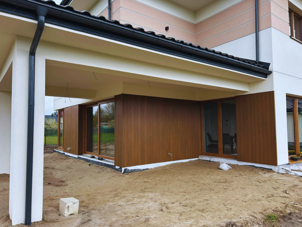 Elewacja domu parterowego pokryta deskami elewacyjnymi Ultrashield US09 w kolorze brązowym, Teak