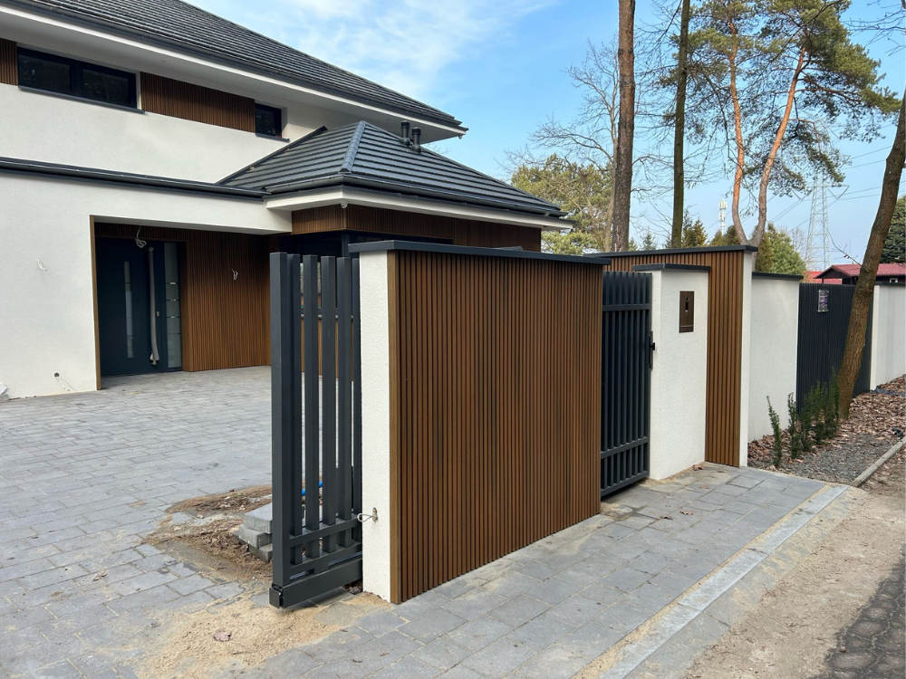 Dom parterowy i ogrodzenie wykończone lamelami elewacyjnymi Ultrashield Naturale UH46 w brązowym kolorze, Teak