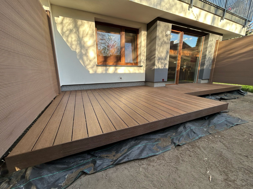 taras w ogordzie przy domu typu "bliźniak" z desek kompozytowych Ultrashield Naturale w kolorze Ipe