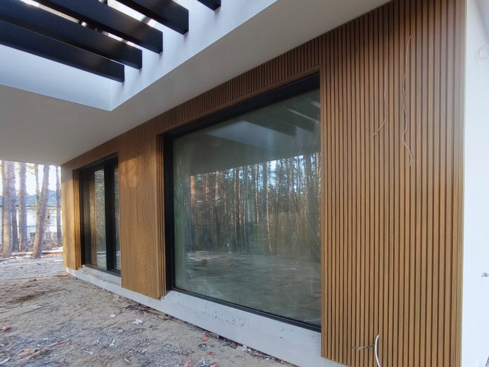 elewacja domu jednorodzinnego wykończona lamelami elewacyjnymi Ultrashield UH46 w kolorze Teak